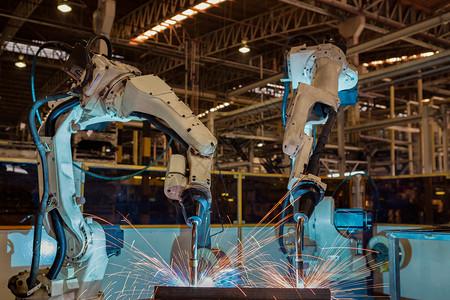 机器人发光排团队机器人在工厂中焊接金属组件部分电子产品汽车背景